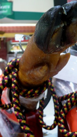 A pig's leg for sale, gift-wrapped in a grocery store.